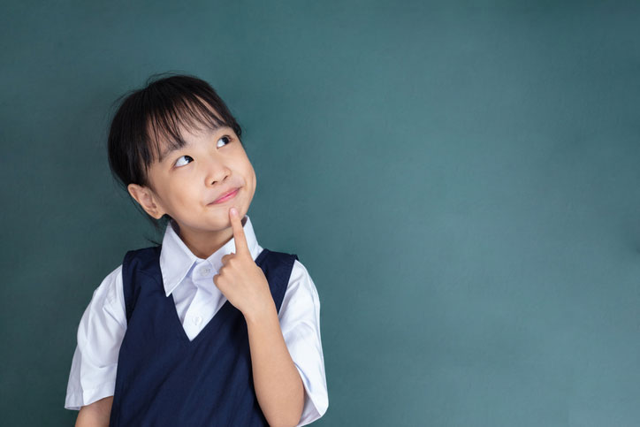Young school girl of Asian descent pondering about something